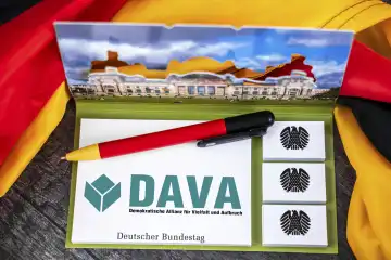 DAVA Partei Logo auf einem Notizblock mit Bundesadler und Deutschem Bundestag abgebildet neben einer Deutschland Fahne. FOTOMONTAGE
