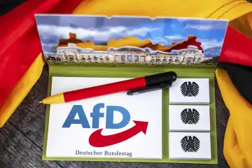 AfD, Alternative für Deutschland Partei Logo auf einem Notizblock mit Bundesadler und Deutschem Bundestag abgebildet neben einer Deutschland Fahne. FOTOMONTAGE
