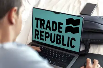 Mann sitz an einem Laptop Computer, im Display ist das Logo der Börse TRADE REPUBLIC zu sehen. FOTOMONTAGE