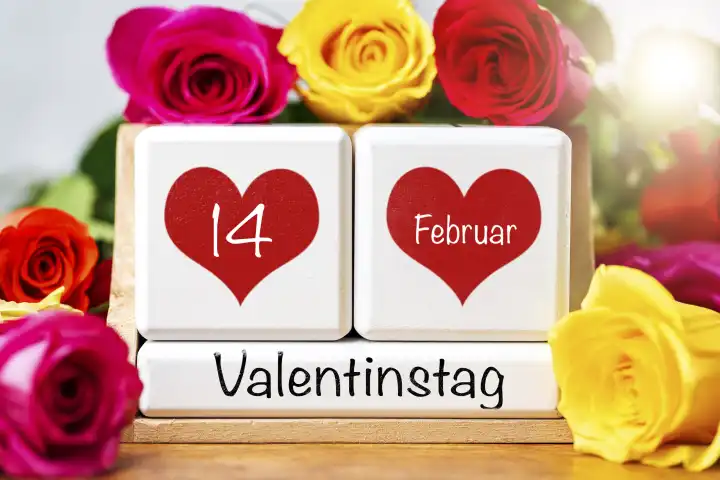 Valentinstag, Gruß auf einem Kalender umgeben von bunten Rosen mit dem Datum 14 Februar in roten Herzen. FOTOMONTAGE