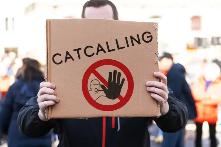 February 22, 2024: Stop catcalling! Demonstrator with a sign and a stop symbol and the inscription: Catcalling. PHOTOMONTAGE