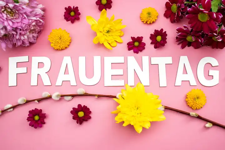 Frauentag, Schriftzug auf rosa Hintergrund mit bunten Blumen und Blüten. Symbolbild Weltfrauentag am 8 März