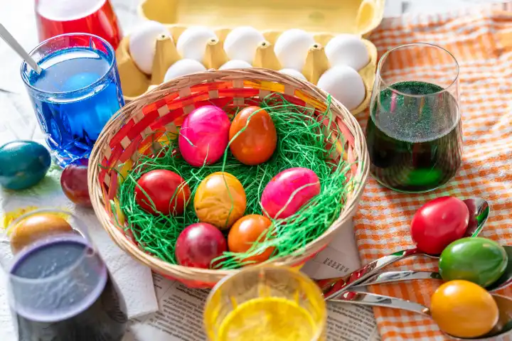 Osternest mit bunten Eiern auf einem Tisch beim Eierfärben zu Ostern