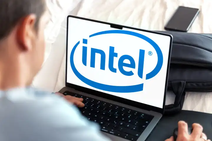 Mann sitzt am Laptop, im Bildschirm das Logo von Intel. FOTOMONTAGE