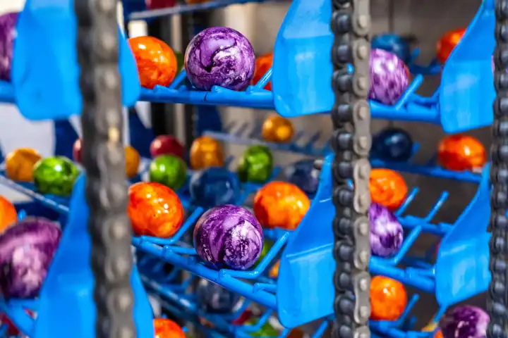 Thannhausen, Bavaria, Germany - 10 March 2024: Brightly colored eggs are dried in a machine after dyeing at Eierfärberei Beham in Thannhausen, Bavaria. Production is running at full speed right before Easter