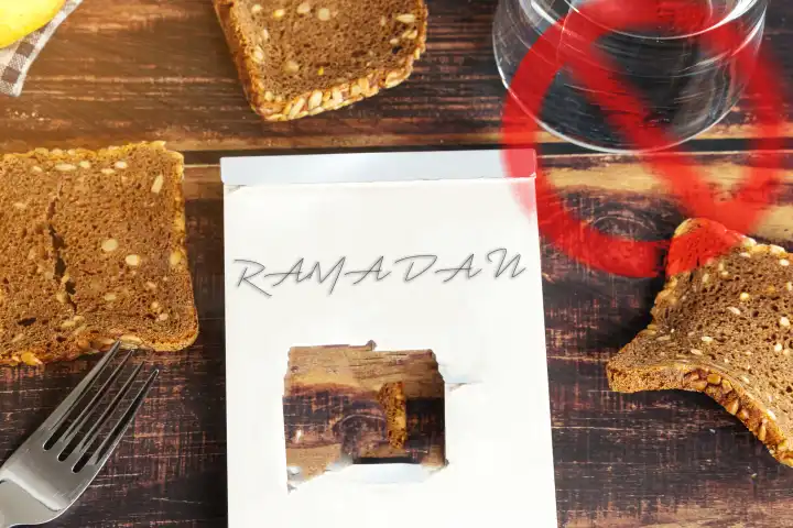 Ramadan, Schriftzug auf einem Block mit einem Loch. Symbolbild Fastenzeit der Muslime. FOTOMONTAGE