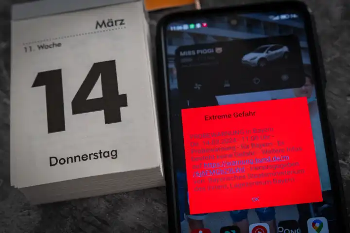Themenbild Probealarm am 14 März um 11 Uhr in Bayern. Smartphone mit der Warnmeldung: Extreme Gefahr, auf dem Bildschirm