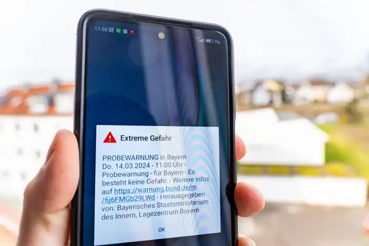 Themenbild Probealarm am 14 März um 11 Uhr in Bayern. Smartphone mit der Warnmeldung: Extreme Gefahr, auf dem Bildschirm