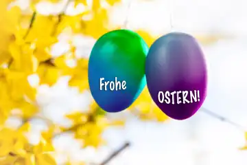 15 March 2024: Happy Easter, greeting on colorful Easter eggs hanging in a tree in spring. PHOTOMONTAGE