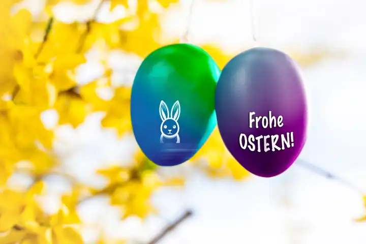 15 March 2024: Happy Easter, greeting on colorful Easter eggs hanging in a tree in spring. PHOTOMONTAGE