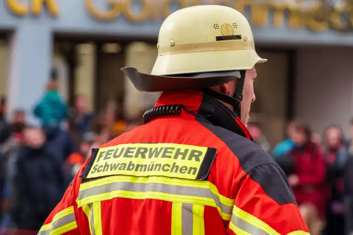 Feuerwehrleute mit Schutzausrüstung und Anzug der Feuerwehr SMÜ, bekleidet mit Feuerwehrhelmen und Reflektoren, auf dem Frühlingsfest in Schwabmünchen