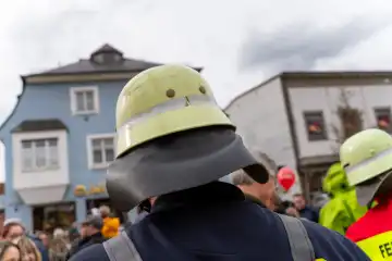 Feuerwehrleute mit Schutzausrüstung und Anzug der Feuerwehr SMÜ, bekleidet mit Feuerwehrhelmen und Reflektoren, auf dem Frühlingsfest in Schwabmünchen
