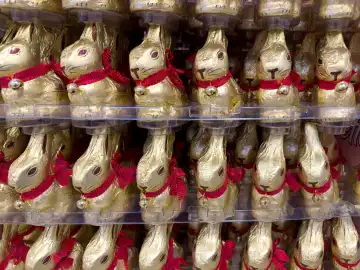 Bavaria, Germany - February 28, 2024: Gold bunnies from Lindt stacked in large quantities in a food supermarket at Easter