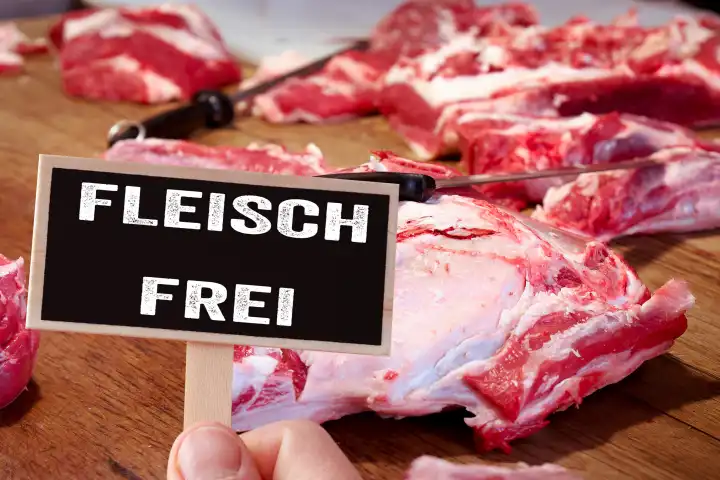 March 27, 2024: Meat-free, diet without meat. Raw red meat on a worktop with a knife at a butcher's. A sign with the inscription: Meat free, for an alternative, vegan and vegetarian diet. Photomontage