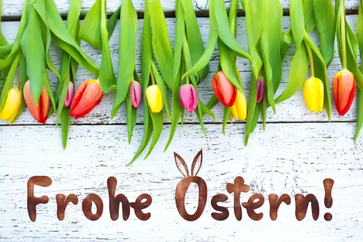 Bunte Tulpen auf rustikalem Holz mit dem Gruß: Frohe Ostern! FOTOMONTAGE