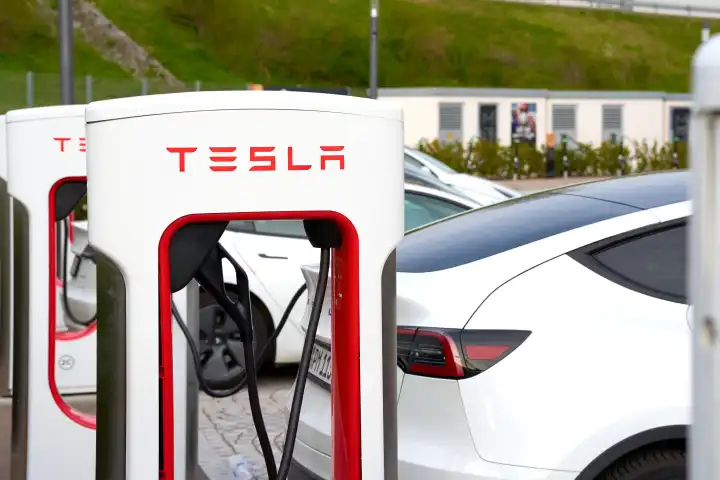 Bavaria, Germany - April 7, 2024: Tesla Model Y charges the battery at a Tesla Supercharger fast charging station