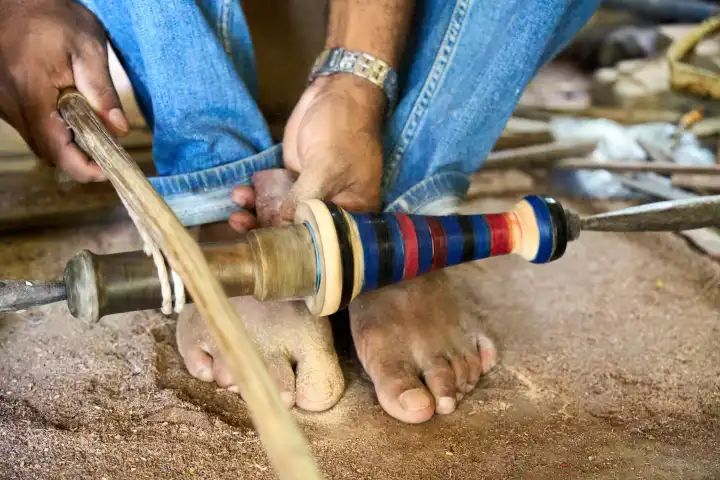 Ein Mann fertigt mit traditioneller Holzbearbeitung mit einem Bogenfußbohrer Skulpturen aus Holz in der Werkstatt in Sri Lanka