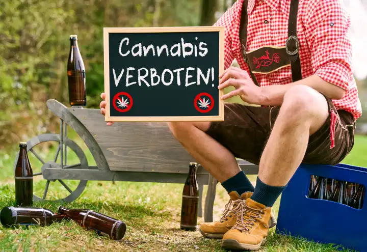 Themenbild Cannabis und Kiffen verboten in Biergärten und Volksfesten in Bayern. Mann in Lederhose hält ein Schild mit Aufschrift: Cannabis Verboten! FOTOMONTAGE