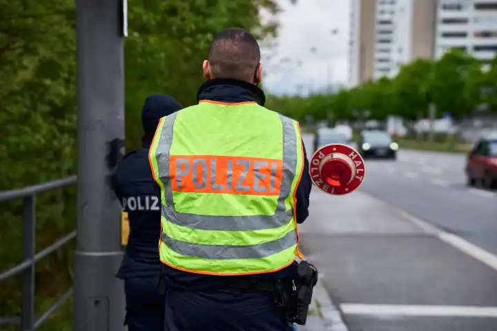 Länderübergreifender Sicherheitstag zur Speedweek bzw. Blitzermarathon in Augsburg. Polizist hält eine Polizeikelle an einer Kontrollstelle