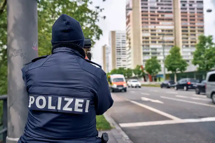 Geschwindigkeitsmessung der Polizei Augsburg anlässlich zum Blitzermarathon 2024. Polizistin mit Lasermessgerät an einer Straße