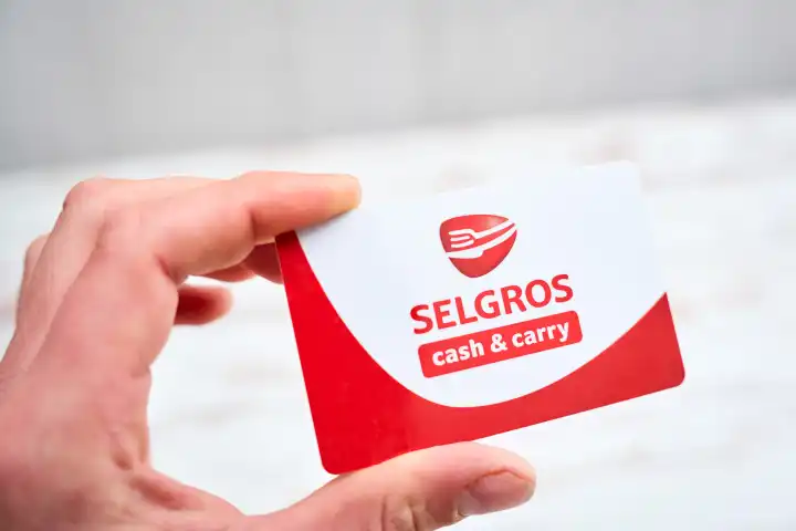 Augsburg, Bavaria, Germany - April 17, 2024: Hand holding a Selgros cash & carry wholesale card