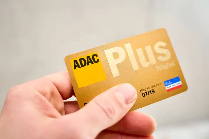 Augsburg, Bavaria, Germany - April 17, 2024: Hand holding an ADAC membership card. ADAC Plus member