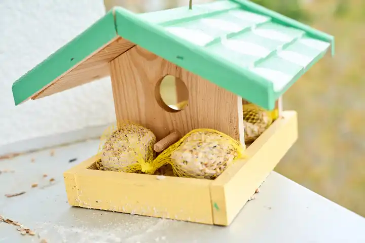 Ein Vogelhaus aus Holz mit Vogelfutter