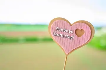 Augsburg, Bavaria, Germany - April 17, 2024: Happy Mother's Day! Greeting on a wooden heart. PHOTOMONTAGE