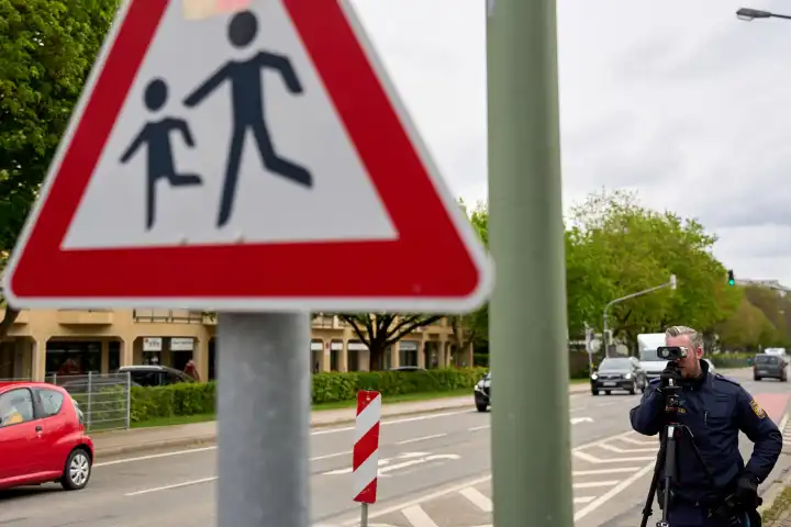 Augsburg, Bavaria, Germany - April 19, 2024: Speed camera marathon in Bavaria. Speed camera check by the police in Augsburg. A police officer measures the speed with a laser measuring device in a 30 km/h zone