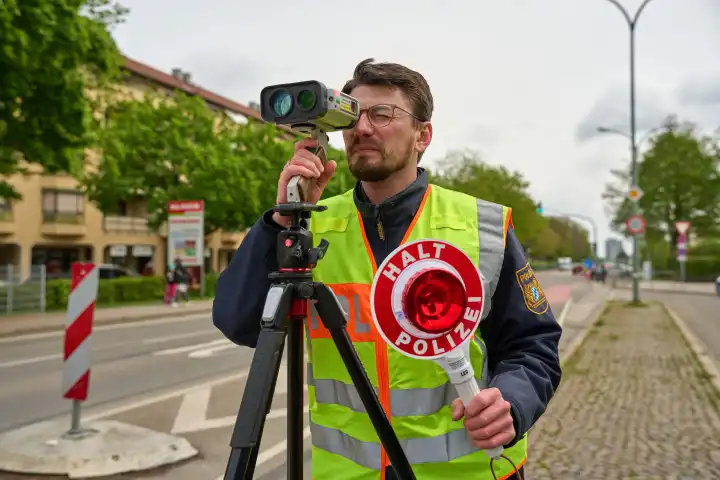 Augsburg, Bavaria, Germany - April 19, 2024: Speed camera marathon in Bavaria. Speed camera check by the police in Augsburg. A police officer measures the speed with a laser measuring device in a 30 km/h zone
