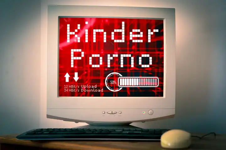 Alter Computer mit Bildschirm auf einem Schreibtisch. Upload und Dowload Symbole mit dem Schriftzug: Kinderporno. Verbreitung von illegaler Pornografie im Internet Konzept. FOTOMONTAGE