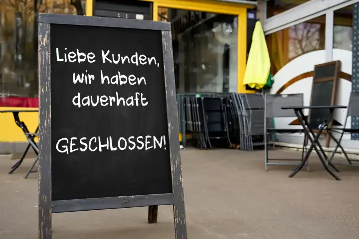 April 22, 2024: Sign in front of a restaurant with the inscription: Dear customers, we are permanently closed! Insolvency concept. PHOTOMONTAGE