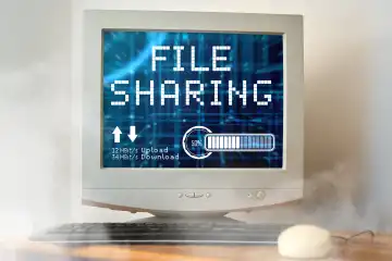 April 22, 2024: Symbolic photo file sharing. An old computer with file sharing written on it is smoking with upload and download rates. PHOTOMONTAGE