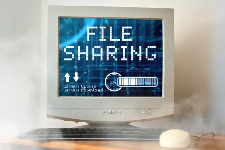 April 22, 2024: Symbolic photo file sharing. An old computer with file sharing written on it is smoking with upload and download rates. PHOTOMONTAGE