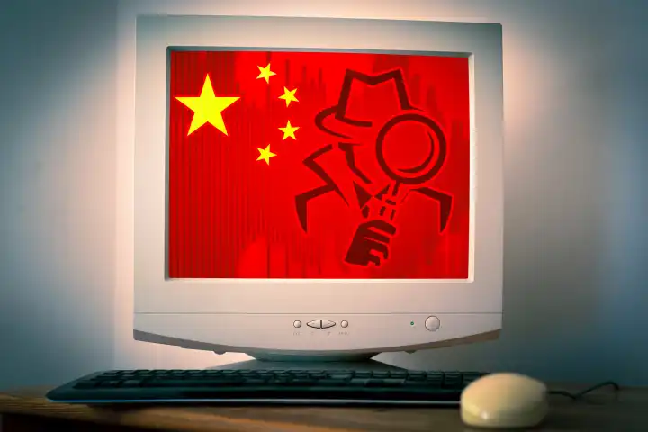Symbolbild China Spionage in Deutschland. Computerbildschirm mit China Flagge udn einem Spion Symbol. FOTOMONTAGE
