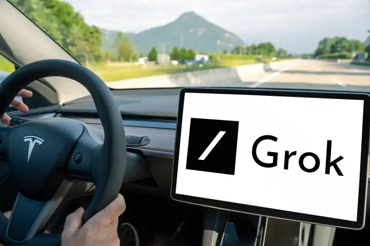 Mann fährt ein Tesla Auto mit dem Logo der X Ki Groko auf dem Bildschirm. FOTOMONTAGE