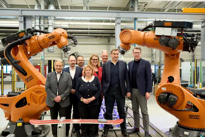 Augsburg, Bavaria, Germany - 24 April 2024: Prime Minister of Bavaria Dr. Markus Söder visits the presentation of the AI Network Augsburg. AI research hall ("Hall 43") of the University of Augsburg. Together with Eva Weber and Markus Blume in front of a KUKA robot