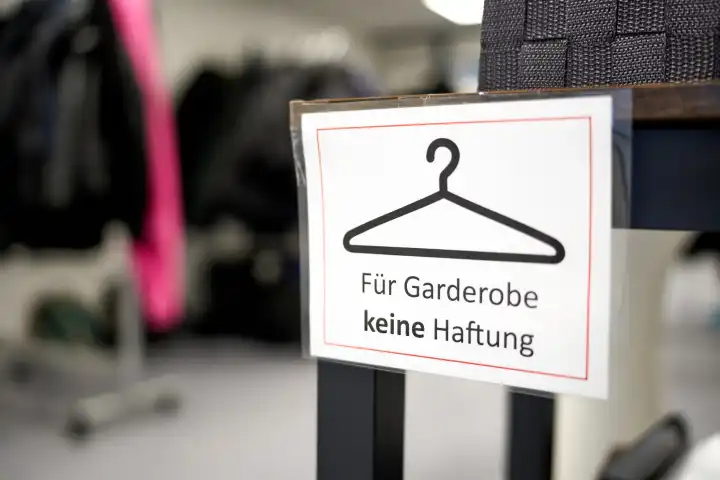 Schild vor der Abgabe von Kleidung an einer Garderobe mit Aufschrift: Für Garderobe keine Haftung