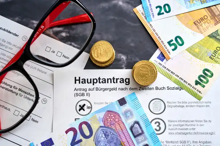 Antrag auf Bürgergeld, Hauptantrag mit Euro Geldscheinen und Münzen. Sozialhilfe Konzept