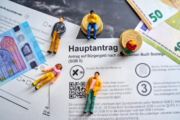 Augsburg, Bavaria, Germany - April 25, 2024: Application for citizen's income, main application with euro banknotes and people figures. Social welfare concept