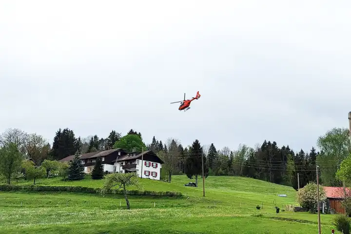 Rettungshubschrauber der Bergrettung Christoph 17 der Bergwacht Kempten im Einsatz im Allgäu in den Bergen nahe der Autobahn