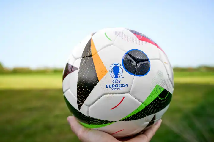 Symbolbild, Hand hält UEFA EURO 2024 offizieller Fußball Spielball von Sportausrüster Adidas. Fußball-Europameisterschaft 2024