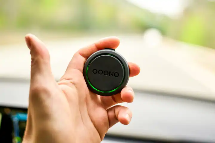CO-DRIVER NO2 bzw. Oono 2 Radarwarner bzw. Blitzerwarner mit Live-Infos im Straßenverkehr in einer Hand in einem Auto auf der Straße