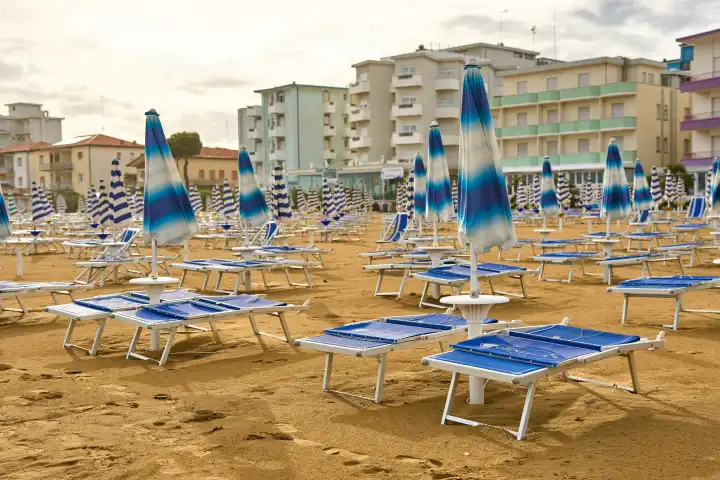 Lido di Jesolo, Italy - 2 May 2024: Closed umbrellas on the beach of Lido di Jesolo in Italy