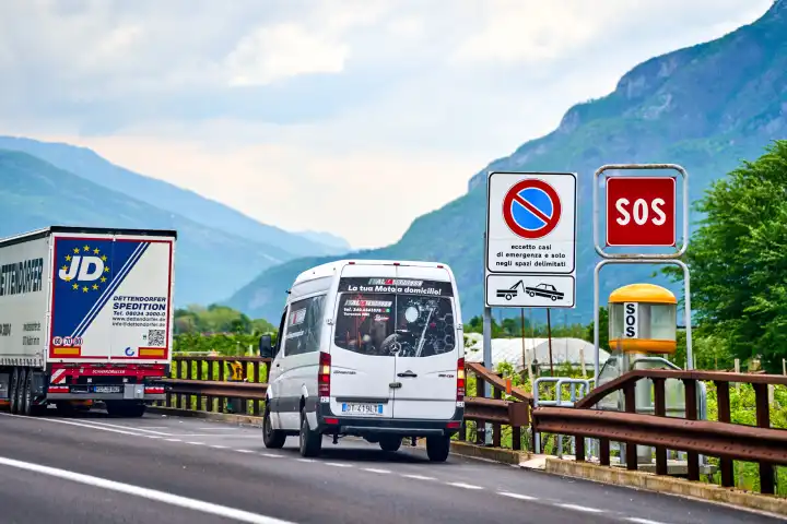  Italy - 01 May : Van with hazard lights behind truck on the highway with a car breakdown next to an SOS emergency call pillar to alert the rescue