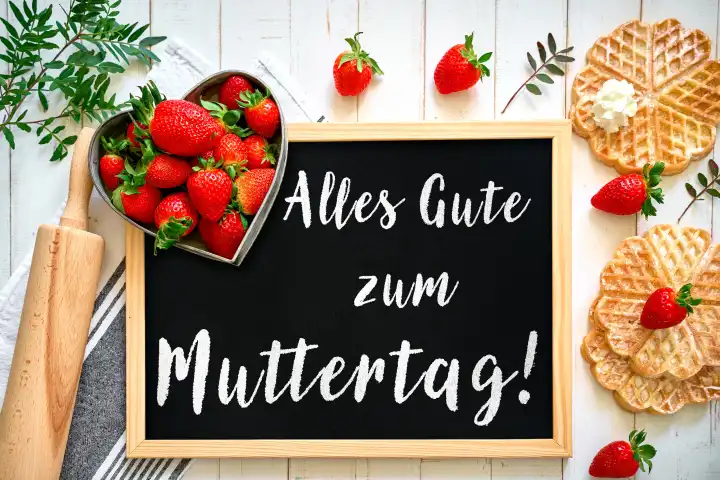 7 May 2024: Happy Mother's Day! Greeting on a sign surrounded by fresh strawberries and waffles. PHOTOMONTAGE