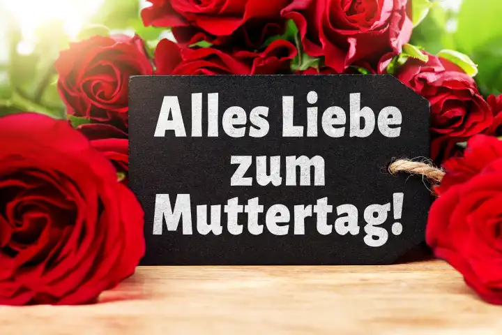 Alles Liebe zum Muttertag! Gruß auf einer Grußkarte vor roten Rosen. FOTOMONTAGE