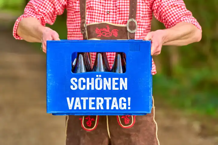 7 May 2024: Man in lederhosen holding a beer crate with the inscription: Happy Father's Day! Greetings for Father's Day. PHOTOMONTAGE