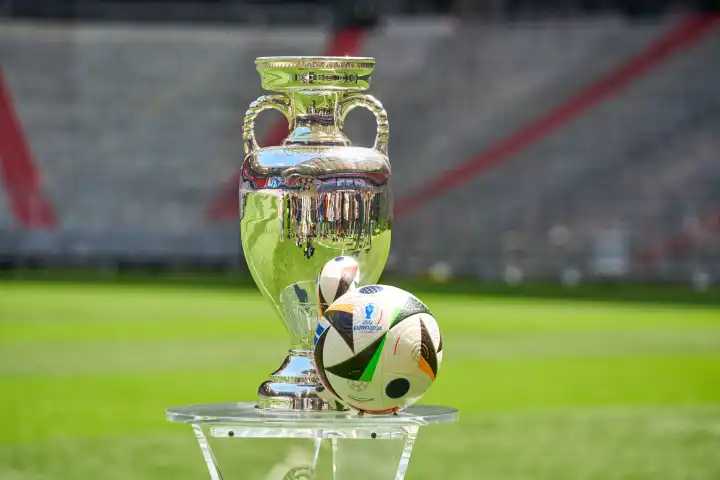 Themenbild Fußball EURO 2024: Henri-Delaunay-Pokal der UEFA EURO 2024 zusammen mit dem offiziellen Spielball der Europameisterschaft von Adidas auf dem Spielfeld der Allianz Arena in München