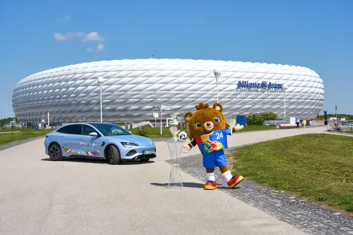 Maskottchen Albärt der Fußball-EM UEFA EURO 2024 mit dem Spielball von Adidas und dem Henri-Delaunay-Pokal vor der Allianz Arena in München